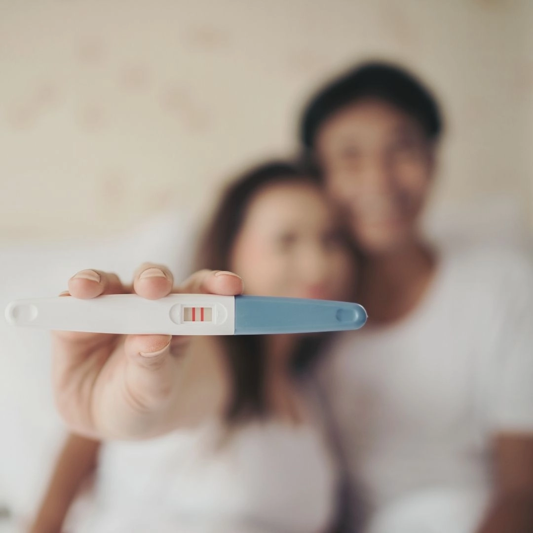 An image of a couple showing a pregnancy test kit